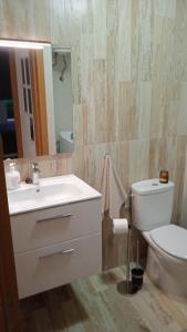 y baño con lavabo, aseo y espejo. en Blue View Hermoso Apartamento Remodelado Ubicación Ideal en Costa Teguise