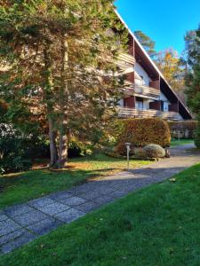 a walkway in front of a building with a tree at Wald und Felsen - Apartment in Ludwigswinkel