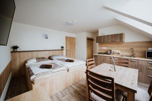 a bedroom with a bed and a kitchen with a table at Penzion U Levandule Strážnice in Strážnice