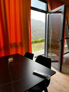 einen Tisch und Stühle in einem Zimmer mit einem großen Fenster in der Unterkunft Green Villa Resort Orange in Dilidschan