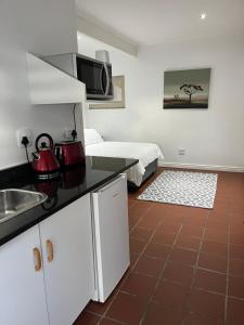 a kitchen with a sink and a room with a bed at Studio 7 on Risa in Port Elizabeth