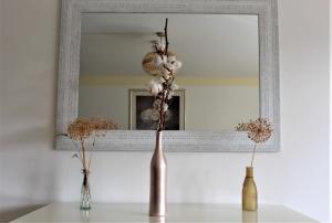 two vases sitting on a table in front of a mirror at FeWo Tulipa Vera mit traumhafter Aussicht in Todtmoos