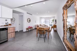 a kitchen and dining room with a table and a mirror at Stylish luxury condo, central location, ocean view, pool, gym in Oranjestad