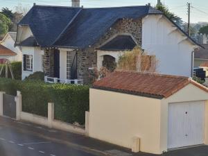 una casa blanca con techo marrón en Capeden maison typique, en Saint-Hilaire-de-Riez