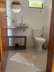 a bathroom with a toilet and a sink and a mirror at Estância Shangri-La in Santa Teresa