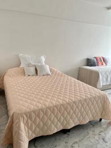 een slaapkamer met een bed met een dekbed bij Departamento Reciclado en Mar del Plata in Mar del Plata