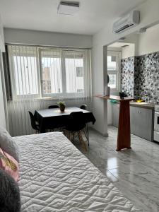 Habitación con cama, mesa y cocina. en Departamento Reciclado en Mar del Plata en Mar del Plata