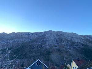 een berg in de verte met huizen ervoor bij Sentralt hus i Rjukan in Rjukan