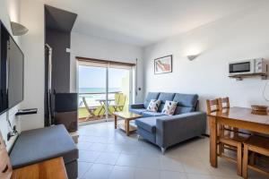 a living room with a couch and a table at Beach House Vista Mar - Praia do Pedrógão in Coimbrão