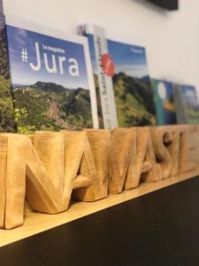 a wooden sign that says jura on a shelf with books at Superbe appartement centre ville proche des pistes in Morez