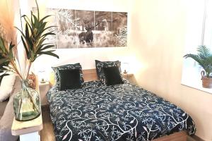 um quarto com uma cama com um edredão preto e branco em Superbe appartement centre ville proche des pistes em Morez