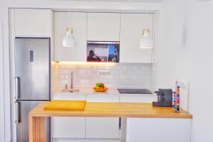 une cuisine avec des placards blancs et un comptoir en bois dans l'établissement Apartamento zahara, à Zahara de los Atunes