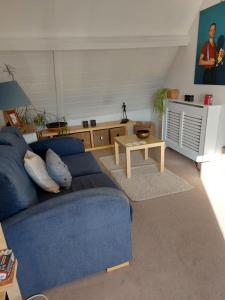 sala de estar con sofá azul y mesa en The Snug, en Goodrich