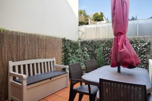 un patio con mesa, sillas y sombrilla en Refugio, en Oporto