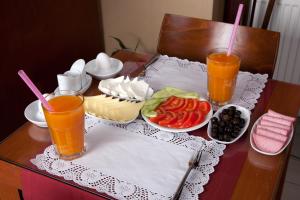 una mesa con una bandeja de comida y dos vasos de zumo de naranja en Sultanahmet Suites, en Estambul