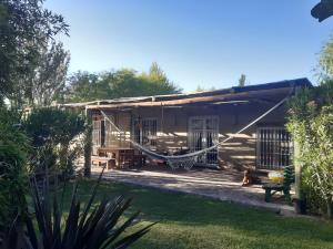a house with a hammock in the yard at Casas de Campo Los Corralitos in Mendoza
