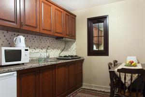 a kitchen with wooden cabinets and a microwave at Sultanahmet Suites in Istanbul