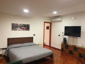 um quarto com uma cama e uma televisão de ecrã plano em La Grotta Stazione em Salerno