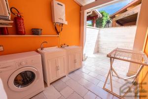 una lavanderia con lavatrice di Cala Golden Apartment a Porto Cesareo