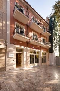 a building with two balconies and a courtyard at Epoch House & The Orange Shop - Adults Only in Nafplio