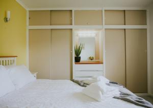 DonVera - Two Bedroom Bungalow with Sea Views في Overcombe: غرفة نوم بسرير ابيض ومرآة