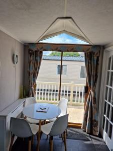 a table and chairs in a room with a window at Elegance on Highfields F28 in Lincolnshire