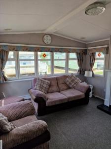 a living room with a couch and some windows at Elegance on Highfields F28 in Lincolnshire