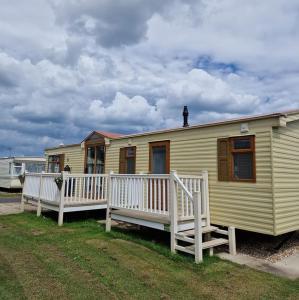 a small yellow house with a porch and a house at Elegance on Highfields F28 in Lincolnshire