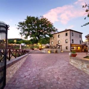 un camino de ladrillo con un edificio y un árbol en Bed & Breakfast Villa Monterosso, en Sassoferrato