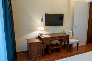 a room with a desk and a tv on a wall at Golf Hotel La Pinetina in Appiano Gentile