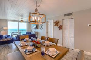 uma sala de jantar e sala de estar com mesa e cadeiras em 707 Sandcastle One em Clearwater Beach