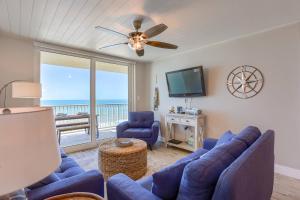 uma sala de estar com sofás azuis e uma televisão de ecrã plano em 707 Sandcastle One em Clearwater Beach