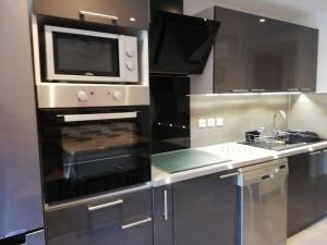 a kitchen with a microwave and a stove at L'Astré in Loupian