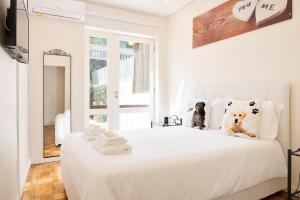 a bedroom with a white bed with a dog sitting on it at Refugio in Porto