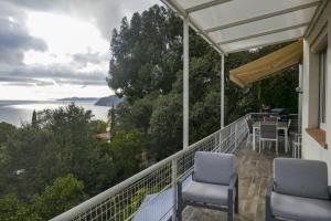 d'un balcon avec des chaises et une vue sur l'eau. dans l'établissement Villa l'Escapade, à Rayol-Canadel-sur-Mer