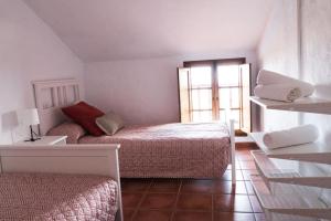 Habitación pequeña con 2 camas y ventana en Vivienda Vacacional Tanganasoga, en La Frontera