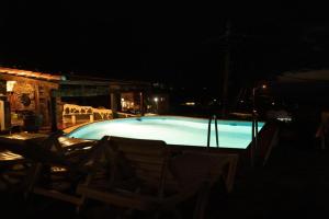 una piscina por la noche con sillas alrededor en Vivienda Vacacional Tanganasoga, en La Frontera