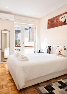a white bedroom with a large white bed and a window at Refugio in Porto