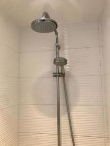 a shower with a shower head in a bathroom at Chez Isa, espace prive, 1ou 2 chambres, terrasse et jardin, entrée autonome, sdb et mini cuisine partagées entre les 2 chambres in Ceyrat