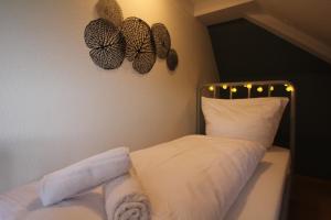 a bedroom with a white bed with lights on the wall at Stylische Ferienwohnung mit Ausblick in Haslach