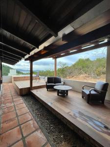 eine Terrasse mit Stühlen, einem Tisch und Aussicht in der Unterkunft Casa Marrom in Bombinhas