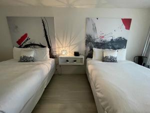 dos camas sentadas una al lado de la otra en una habitación en Newly Room in cozy hotel with Super location to the Parks, en Kissimmee