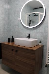 La salle de bains est pourvue d'un lavabo blanc et d'un miroir. dans l'établissement Apartmani Paula, 