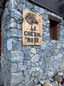 una señal en el costado de una pared de piedra en Le cheval noir 37 (6-7 couchages ), en Valmorel