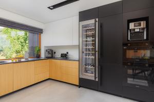 a kitchen with black cabinets and a refrigerator at Mirador Stay in Sierzawy