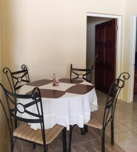 a table with chairs and a white table cloth on it at Valentine's Castle in Saint Annʼs Bay