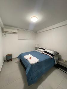 1 dormitorio con 1 cama azul en una habitación en Suite para pareja full amoblada con netflix internet sin agua caliente, en Guayaquil