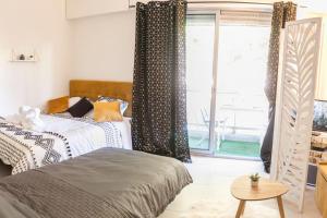 a bedroom with two beds and a large window at Résidence Bord de Mer-Terasse-plage prado David in Marseille