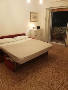 una camera con un grande letto e una finestra di Casa Flegrea Bagnoli a Napoli