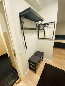 Zimmer mit einer Bank, einem Spiegel und einem Bett in der Unterkunft 1-bedroom loft in Siena Tirgus in Riga